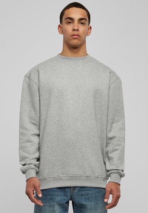 Gray sweatshirt with ribbed crew neckline and cuffs, featuring a relaxed fit and soft, textured fabric, paired with blue jeans.