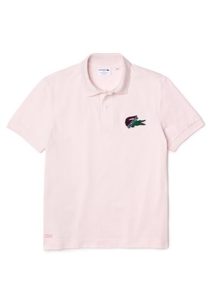 Jasnoróżowa koszulka polo Lacoste z krótkim rękawem, kołnierzykiem, zapinana na dwa guziki, z haftowanym logo krokodyla na piersi.