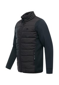 Topattu takki, jossa korkea kaulus, musta, jossa vetoketjullinen tasku ja kontrastiväriset neulotut hihat. Sileä pinta, tikattu kuvio.