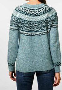 Pull bleu clair avec un empiècement à motifs comportant des dessins en zigzag blancs et bleu foncé. Manches longues, poignets et ourlet côtelés. Texture douce.