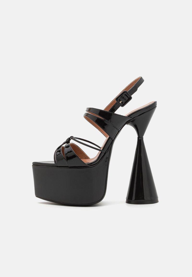 Schwarze Lackleder-Platform-Sandalen verfügen über einen dicken konischen Absatz, einen Knöchell riemen mit Schnalle und ein überkreuztes Riemendesign an der Vorderseite.