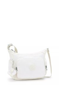 White shoulder bag made from soft material, featuring a front pocket, adjustable strap, and a decorative charm.