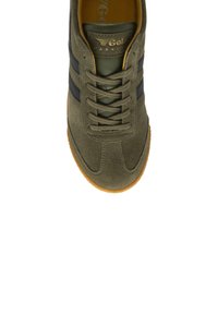 Sneaker in suede verde con strisce nere, punta arrotondata e lacci tonali. Include anche una suola in gomma testurizzata e un dettaglio del logo dorato.