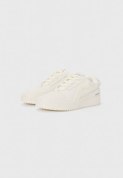 Sneaker bianchi con una superficie liscia, punta arrotondata, lacci frontali e una suola resistente. Presentano un logo laterale e dettagli di cucitura sottili.