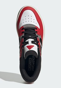 Sneaker atletica rossa, bianca e nera realizzata in materiali in pelle e rete, con punta forata, suola testurizzata e soletta Cloudfoam Comfort.