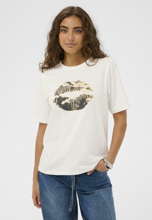 Fehér rövid ujjú póló arany és terepmintás ajaknyomat mintával az elején. Az anyag sima és könnyű hatású. Kényelmes, laza szabás.