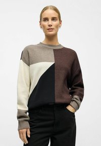Striktrøje med et geometrisk farveblokdesign i nuancer af brun, creme og sort, med rund hals og ribbet manchetter.