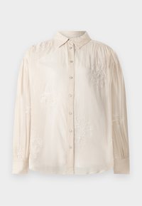Blusa bege de manga longa com frente abotoada, apresentando bordados florais brancos e detalhe de ombreiras franzidas. Textura de tecido suave.