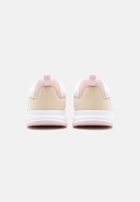 Paire de baskets blanches et beiges avec des accents roses vues de dos sur un fond gris clair uni.