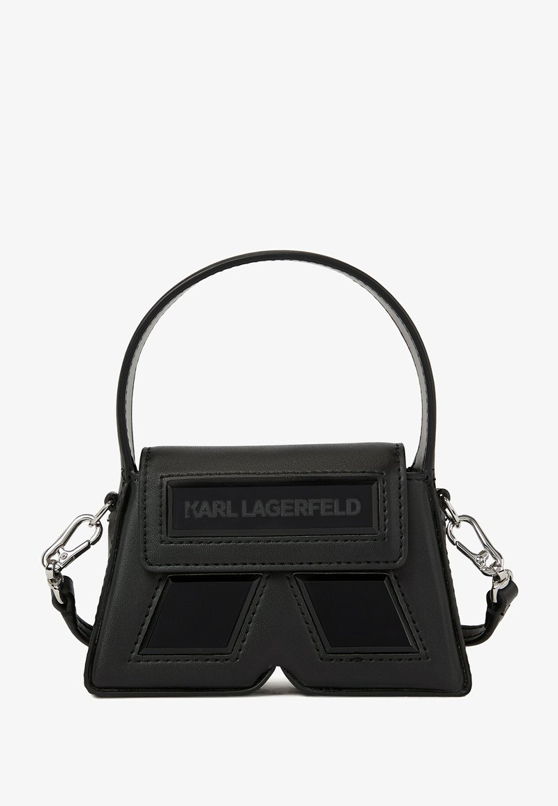 Melna ādas rokassoma ar strukturētu, stūrainu dizainu. Izceļas ar priekšējo logotipa uzšuvumu un sudraba detaļām. Īsa rokturis un noņemams siksna.