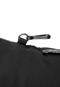 Zwarte stoffen tas met een gladde textuur, een clipsluiting en een klein label aan de zijkant. Het ontwerp is minimalistisch en functioneel.