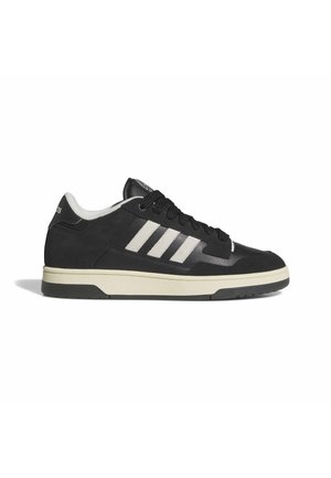 Zapatilla baja negra de Adidas con suela blanca, tres rayas blancas en el lateral y cordones negros, mostrada desde el lado exterior.