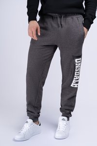Pantalones deportivos grises con cintura ajustable, que presentan un gráfico negro en el costado, combinados con zapatillas blancas. Tejido suave y diseño ajustado.