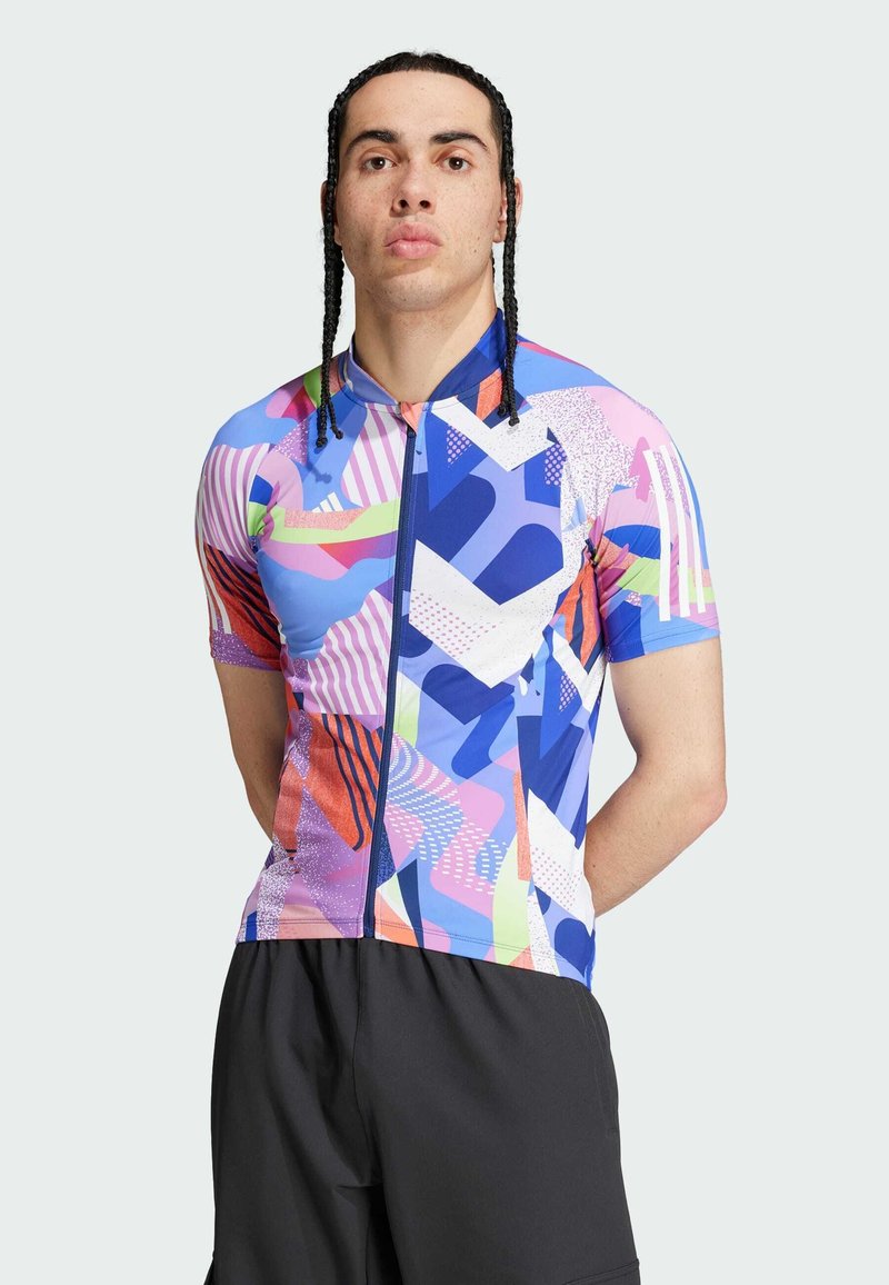 Maillot de ciclismo de manga corta con un patrón geométrico multicolor en tonos de azul, rosa y naranja; incluye una cremallera en la parte frontal.