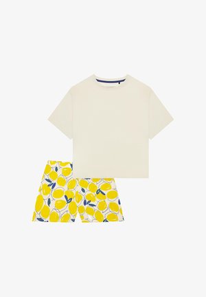 Roomkleurig katoenen T-shirt met korte mouwen, gecombineerd met witte shorts met een geel citroenpatroon en blauwe accenten. Eenvoudig ontwerp, casual pasvorm.