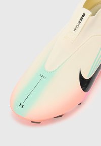 Nike nogometna cipela s gradijentnim dizajnom u prijelazu iz svijetle kreme u ružičastu i zelenu boju, s crnim swoosh logotipom i teksturiranim površinskim detaljima.