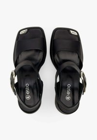 Zwarte leren blockhakken sandalen met open teen, enkelbandje en metalen gespsluiting. Heeft een gladde textuur en vierkante vorm.