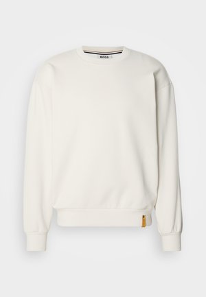 White sweatshirt with a crew neckline, ribbed cuffs, and hem, featuring a small yellow logo tag on the left side. Smooth texture.