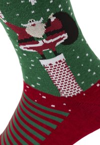 Groene en rode sokken met een kerstmanontwerp, voorzien van sneeuwvlokken en een schoorsteenpatroon, met gestreepte accenten op het rode gedeelte.