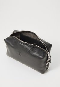 Black leather pouch with a textured exterior, silver zipper, and a chain accent. Interior is lined and includes a small compartment.