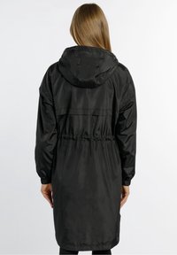 Schwarzer wasserdichter Parka mit Kordelzug an der Taille, langen Ärmeln und verstellbarer Kapuze. Verfügt über eine glatte Textur und knielanges Design.