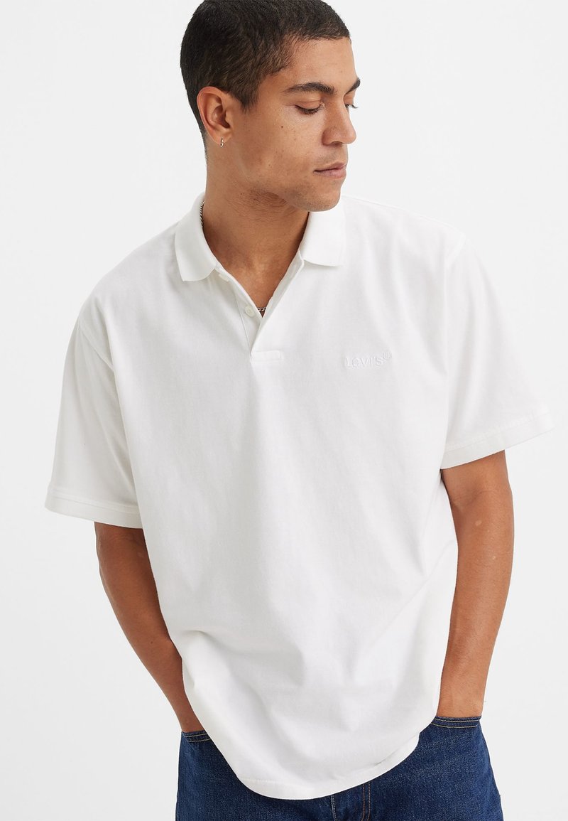 Hvit polo skjorte laget av bomull, med korte ermer, en klassisk krage, og en subtil Levi's-logo brodert på brystet.