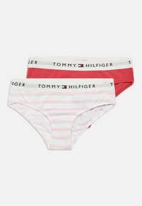 Dva para ženskih gaćica Tommy Hilfiger: jedan čvrsto crven, jedan bijel s ružičastim prugama. Oba imaju elastčnu traku u struku s logom.