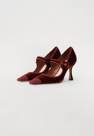 Chaussures à talons hauts en velours bordeaux avec un bout pointu, un capuchon rose contrastant et une fine sangle avec une boucle en or sur le côté.