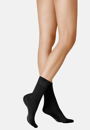Schwarze Knöchelsocken aus weichem Material, mit einem gerippten Bündchen und einer glatten Textur ohne sichtbare Muster oder Akzente.