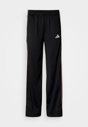 Černé sportovní kalhoty s elastickým pasem, opatřené růžovými pruhy po stranách a vyšitým logem na horní levé noze.