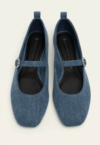 Bailarinas de denim con tirante estilo Mary Jane y hebilla decorativa, punta cuadrada y tejido texturizado en un tono azul oscuro.