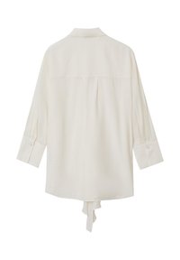 Blusa cream a maniche lunghe con colletto, polsini button-down e dettaglio legato sul retro. Tessuto morbido con una vestibilità leggermente ampia e senza motivi visibili.