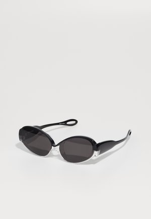Black and clear oval sunglasses with dark lenses and sleek, elongated arms. The frame has a glossy finish. Notable clear accents at the front.