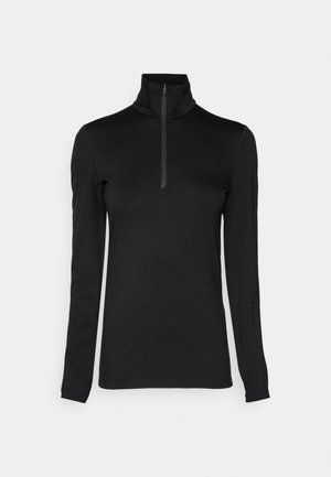 Schwarzes Langarmshirt mit hohem Kragen und halbem Reißverschluss. Glatte Textur, enganliegendes Design und stromlinienförmige Silhouette.
