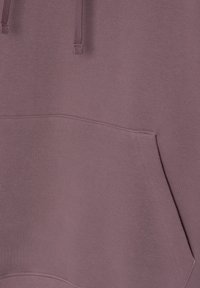 Gros plan sur un sweat à capuche mauve montrant la poche kangourou avant et les cordons de serrage.