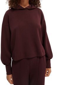 Burgundowy hoodie z długimi, bufiastymi rękawami i luźnym krojem. Wykonany z miękkiego materiału, o prostym wzorze i subtelnej teksturze.