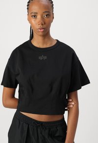 Svart kortärmad t-shirt i mjuk bomull, med rund halsringning, korta ärmar och en subtil logotryck på bröstet.