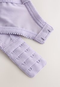 Lavender bra clasp with three rows of hooks and eyes, showing mesh and soft fabric stitching details on a light background.