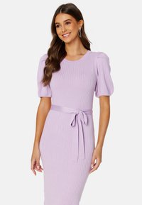 Abito a maglia lilla con texture a costine, maniche a sbuffo corte e una cintura legata in vita. Presenta un collo rotondo e una silhouette aderente.