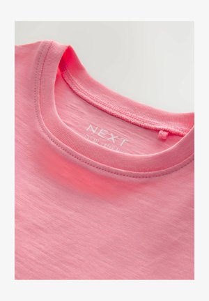 Pink bomulds T-shirt med rund halsudskæring og synlige stikninger. Mærket "NEXT" trykt indeni kraven. Blød tekstur, enkelt design.