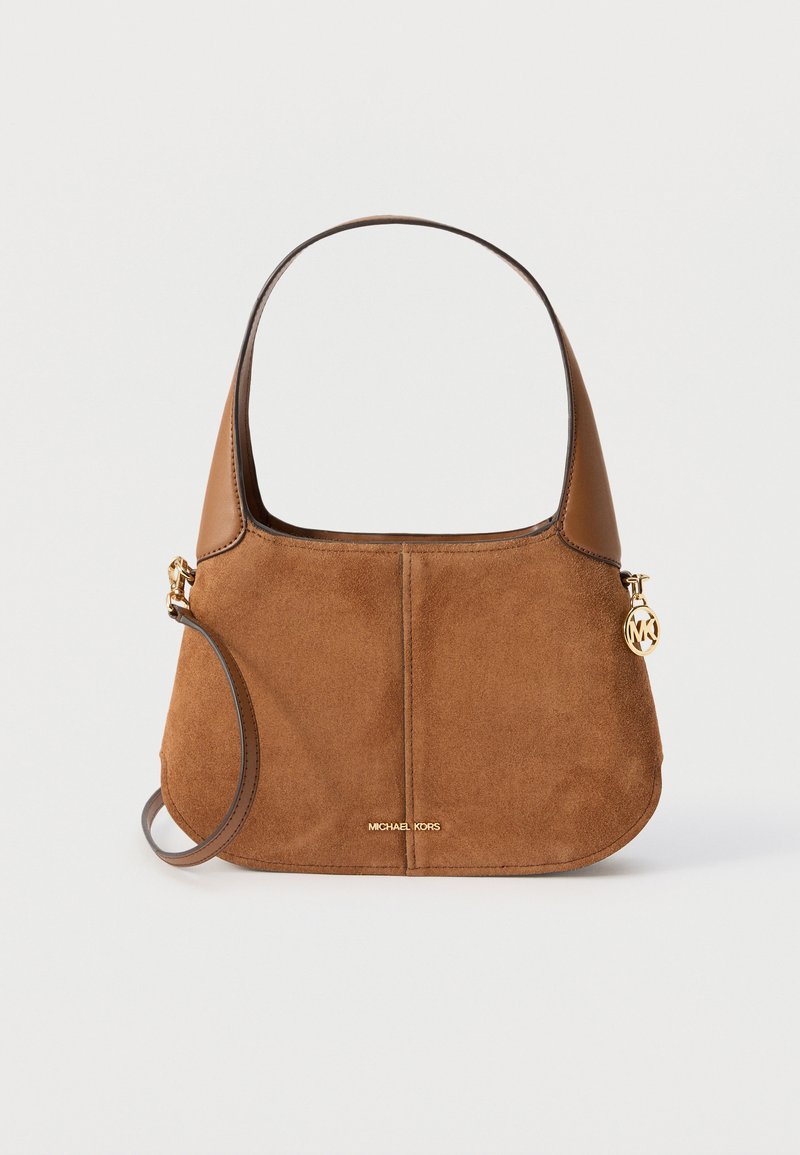 Sac à main en daim et cuir marron avec des anses courtes et longues, logo Michael Kors doré et pendentif circulaire doré à droite.