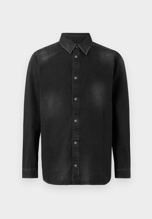 Chemise en denim noir avec un col à rabat, des manches longues et une fermeture à boutons sur le devant. Présente une décoloration subtile et une coupe ajustée.