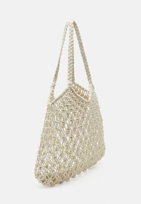 Tkaná slámová taška v přírodní barvě, má prostorný design, dvě splétané rukojeti a otevřený síťovaný vzor pro lehké nošení.