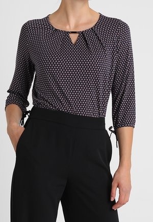 Donkerblouse met patroon en driekwartmouwen, met een keyhole-hals en een subtiel geometrisch ontwerp in contrasterende kleuren.