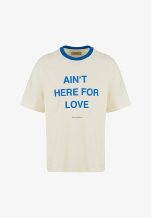 Cremefarbener Baumwoll-T-Shirt mit blauem geripptem Rundhalsausschnitt und in großen Buchstaben bedrucktem Text: "NIE FÜR DIE LIEBE HIER". Lässige Passform, kurze Ärmel.