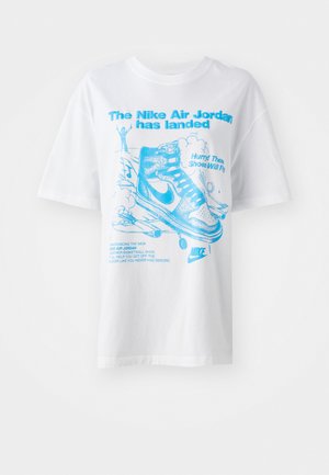 T-shirt en coton blanc avec texte graphique bleu et illustrations de chaussures Air Jordan et d'une silhouette. Manches courtes et coupe décontractée.
