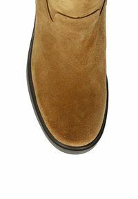 Tan suede ankle boot with a round toe and a black rubber sole. Smooth texture with minimal stitching and a clean, simple silhouette.