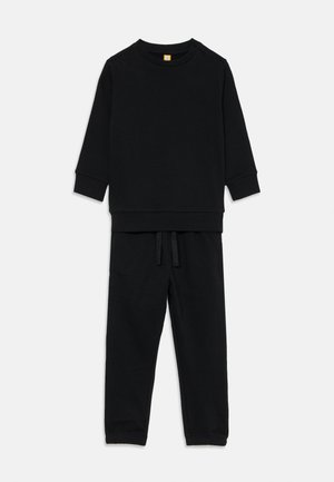 Czarny zestaw bluzy i spodni dresowych, wykonany z miękkiego materiału. Bluza ma okrągły dekolt i długie rękawy; spodnie mają elastyczny pasek w talii i sznurki.