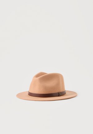 Chapeau fedora en feutre marron clair avec un large bord et une bande en cuir marron foncé posé sur un fond blanc.