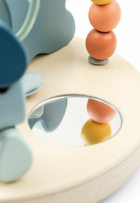 Juguete de madera con cuentas de colores apiladas y un pequeño espejo redondo sobre una base de madera clara, reflejando parte de las cuentas y una forma azul.